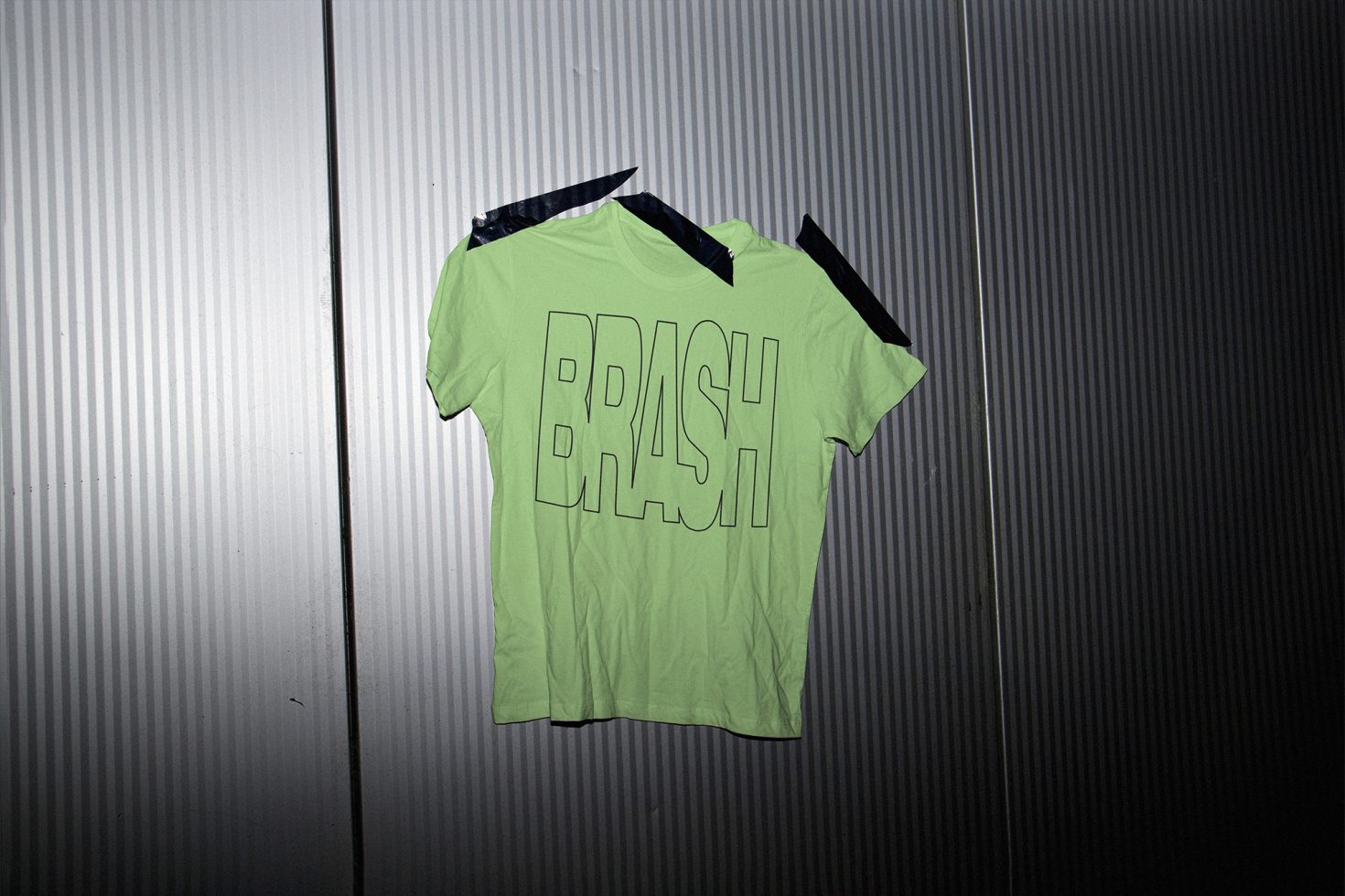 Lime green t-shirt with bold black text mockup on metal background for designers looking for urban style apparel presentations.